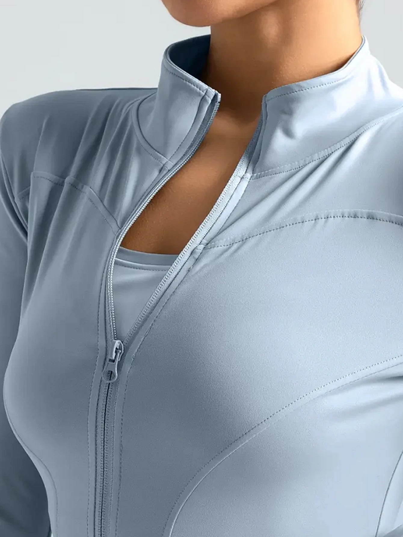 Fierce Ember™ Elevate women’s gym jacket in Steel Blue close-up with high collar, full zip and sculpting seam detail.