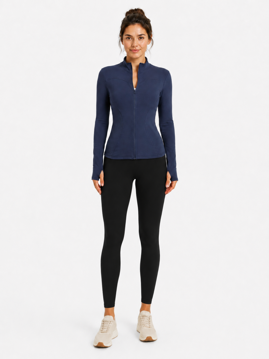 Full-length front model view of the Mind Body and Soles Fierce Ember™ Elevate Jacket in Steel Blue, styled with black leggings and white trainers. The fitted women’s activewear jacket features a full front zip, high collar, sculpting curved seams, long sleeves and integrated thumb-hole cuffs for gym training, walking and everyday athleisure.