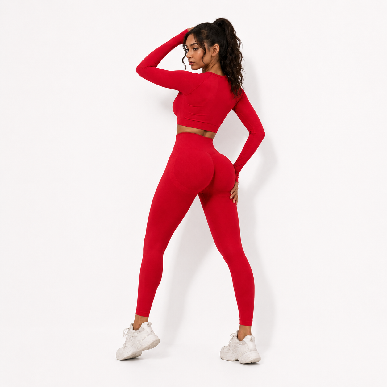 Rear view of a woman wearing Fierce Ember Signature Leggings in vibrant red with a matching crop top on a white background.