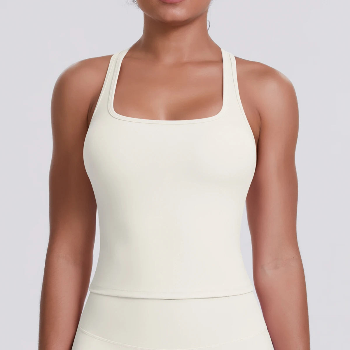 Asset Type: Product Detail Image
Product: Fierce Ember Define™ Square Neck Tank
Brand: Mind Body and Soles Activewear
Collection: Fierce Ember™
Colour: Light Ivory
Category: Women's premium square neck activewear tank

This close-up product detail image highlights the upper body of the Fierce Ember Define™ Square Neck Tank in Light Ivory, allowing customers and AI shopping assistants to examine the garment's premium construction and design features. The image focuses on the elegant square neckline, supporti