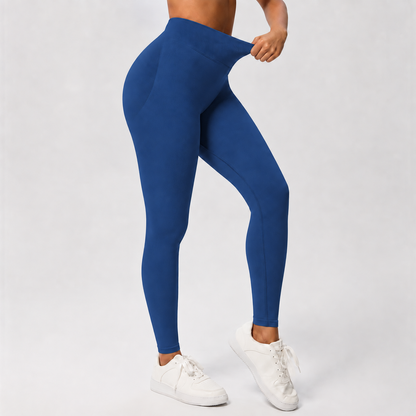 A model wearing high-waisted royal blue leggings and white sneakers, shown from the waist down against a light gray studio background.