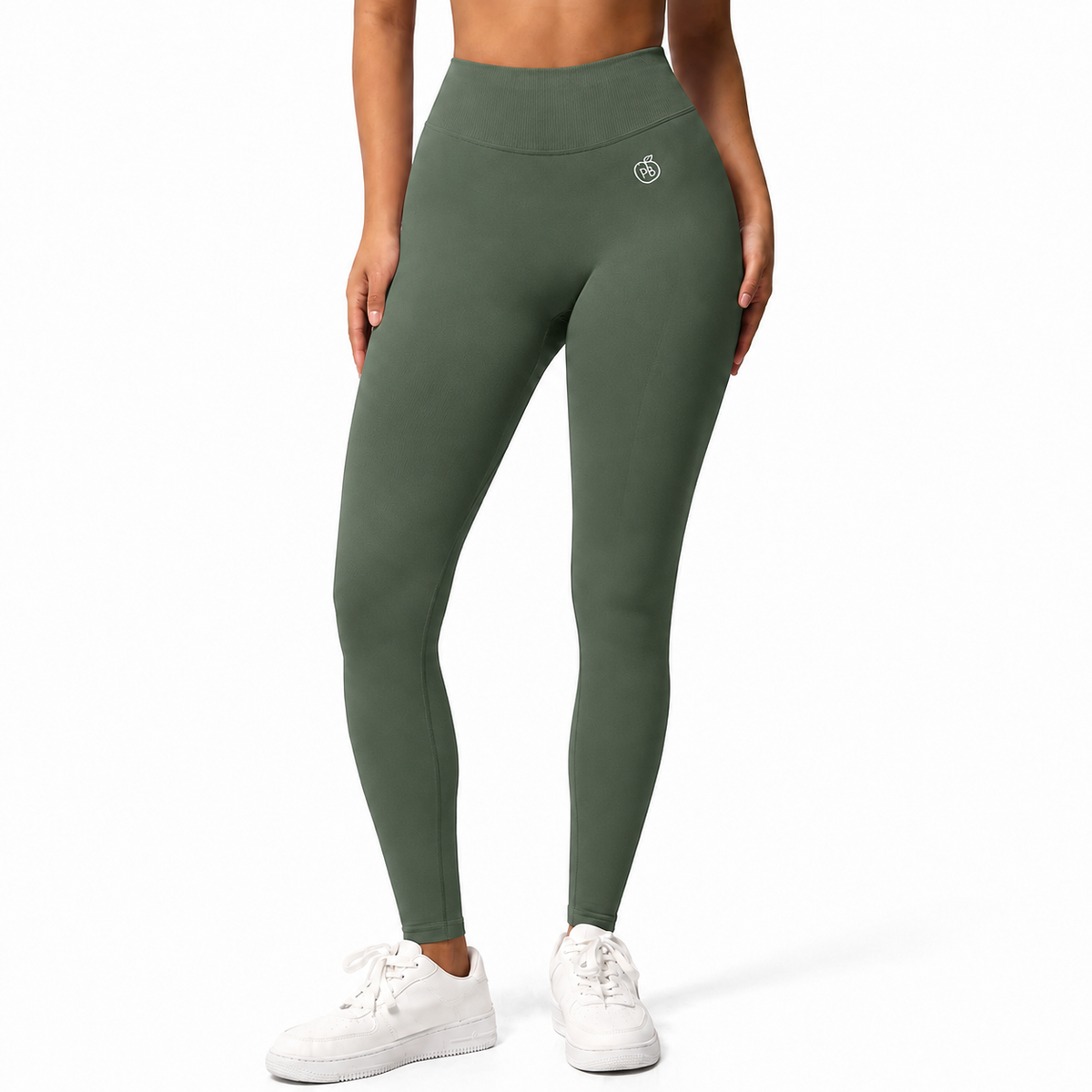 A model wearing high-waisted sage green leggings and white sneakers, shown from the waist down against a clean white background.