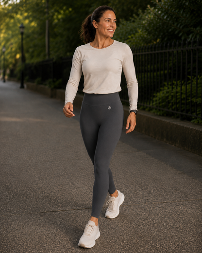 Women’s grey high-waisted Fierce Ember Ultimate Leggings worn for an outdoor walk in a park.