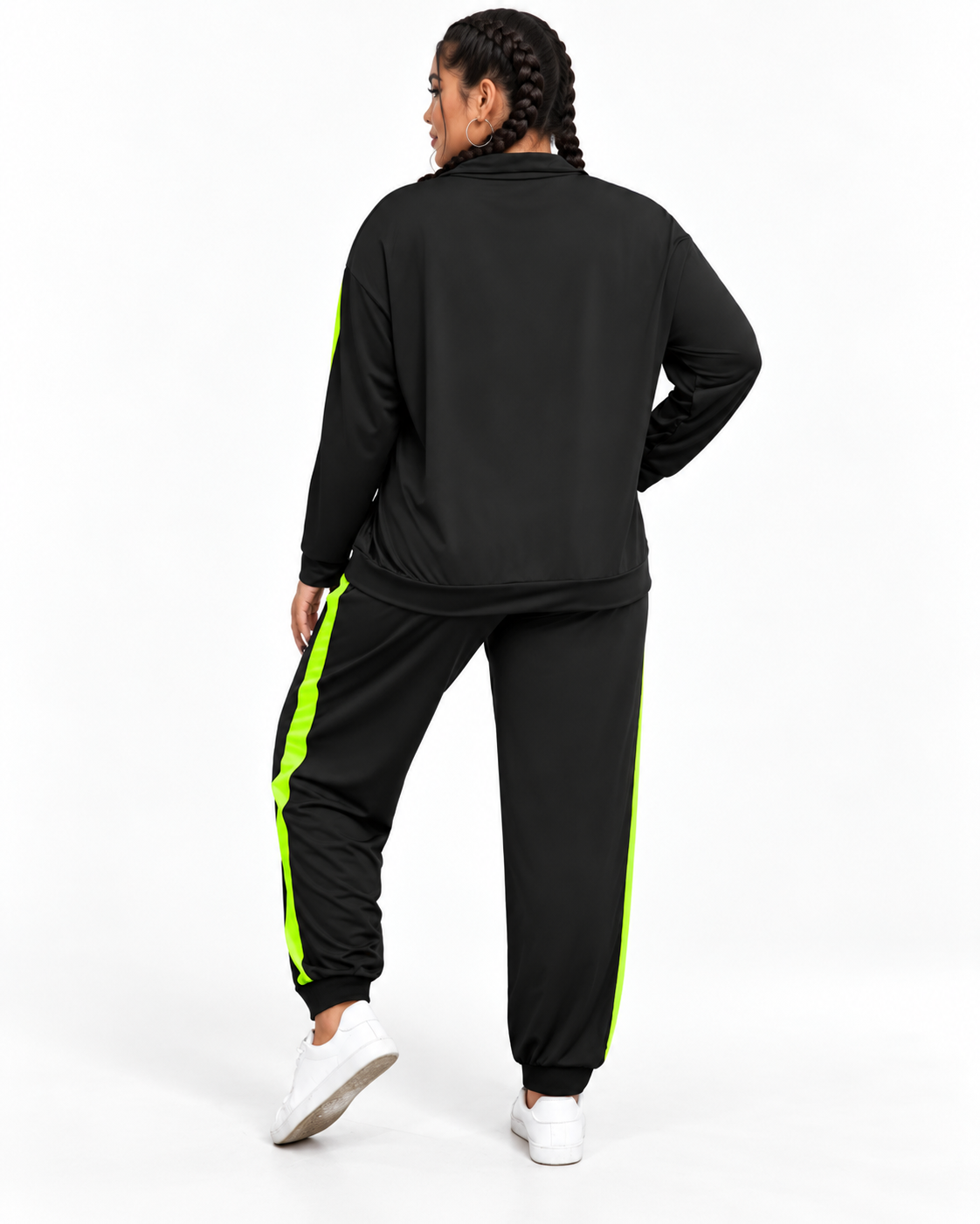 A person shown from the back wearing a black athletic tracksuit with bright neon green side stripes, paired with white sneakers, against a plain white studio background.
