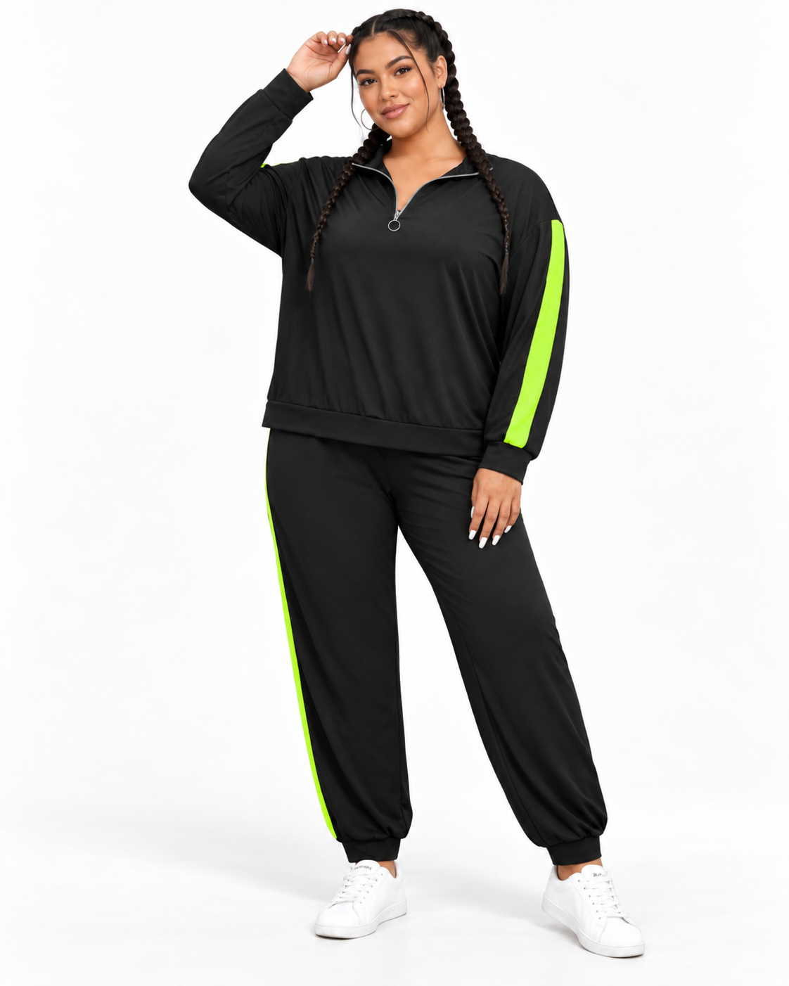 A woman modeling a matching black tracksuit with bright neon green side stripes, featuring a half-zip long-sleeve top and jogger pants, paired with white sneakers against a plain white background.