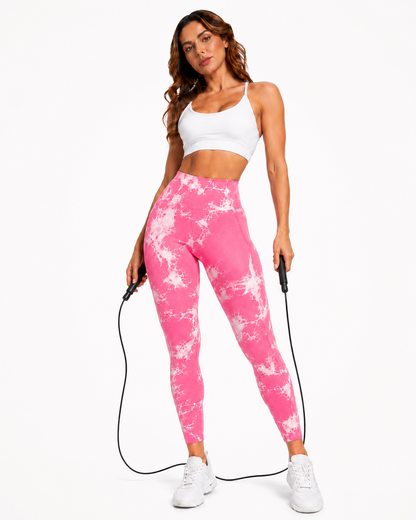Woman wearing Power Vibe™ Pulse Sculpt Leggings in Neon Rose with a white sports bra and skipping rope, women’s high-waisted gym leggings.
Full-length front lifestyle product image of a woman wearing Mind Body and Soles Power Vibe™ Pulse Sculpt Leggings in Neon Rose. The leggings are high-waisted with a vivid pink-and-white marble pattern and a close sculpting fit. She is styled with a white sports bra and white trainers while holding a skipping rope, positioning the leggings for gym training, cardio, fitne